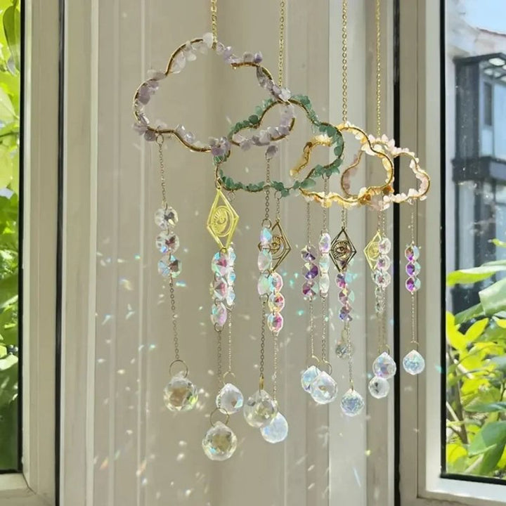 Kreativ gestalteter Fensterschmuck mit einer Wolke aus Mineralsteinen und einem zentralen goldenen Auge